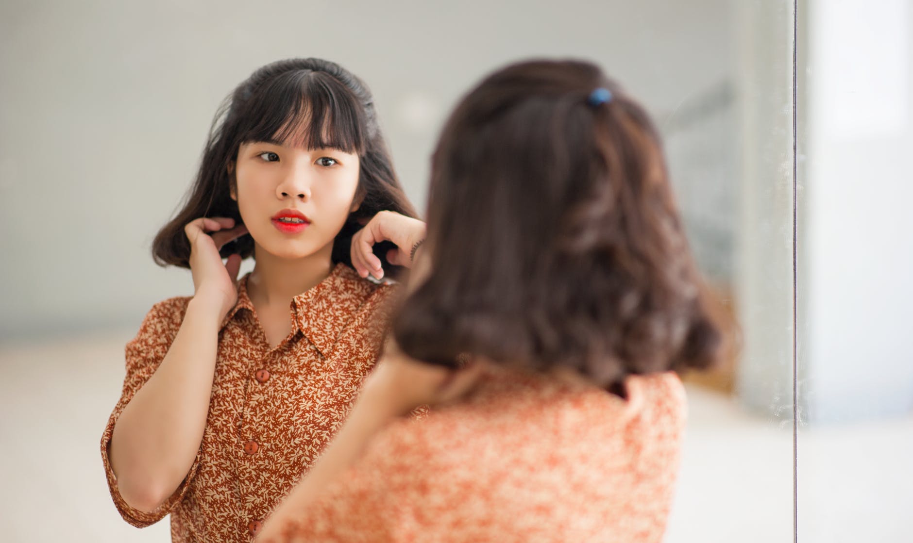 woman standing in front of the mirror