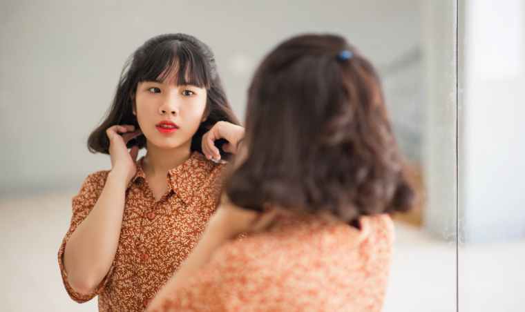 woman standing in front of the mirror